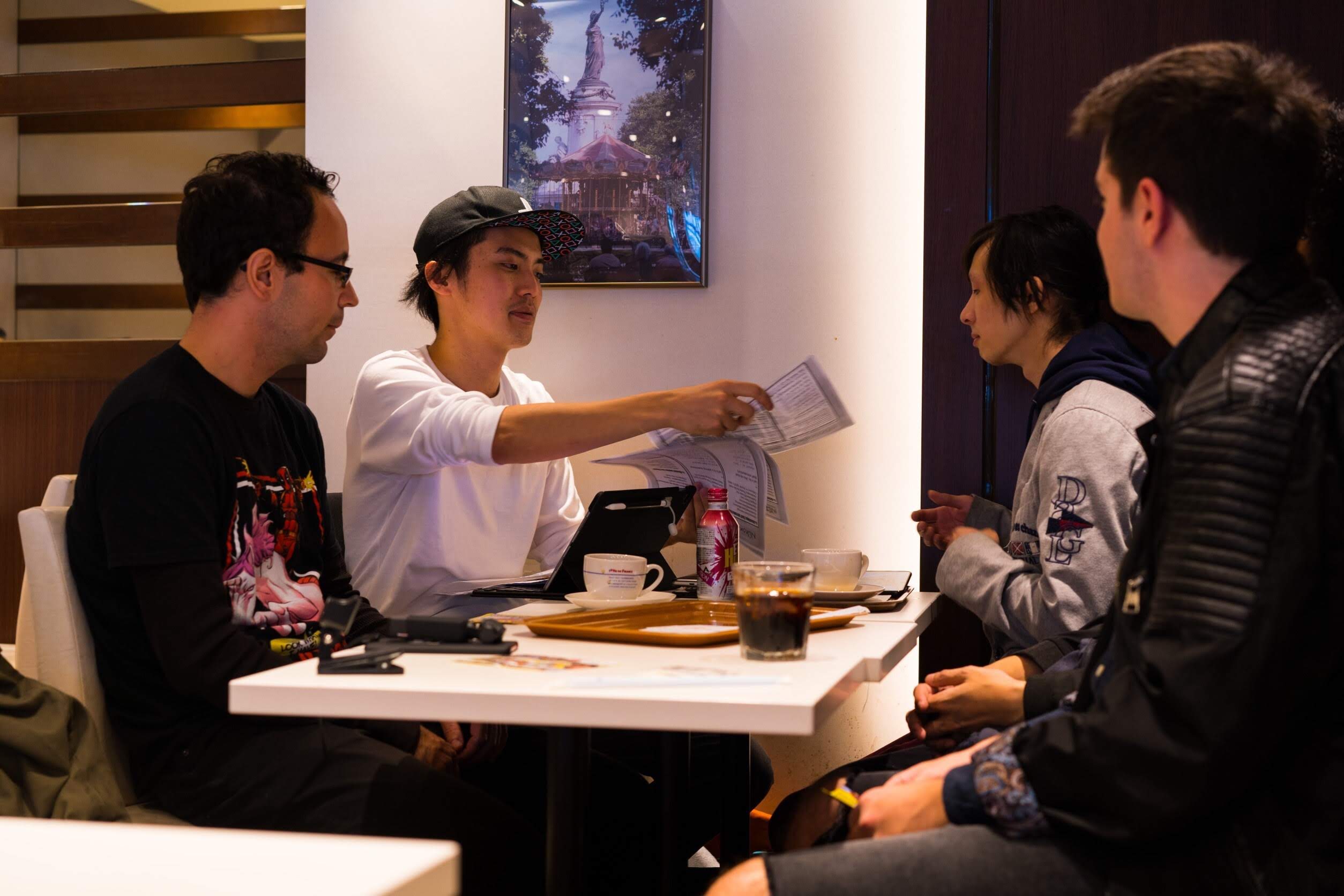 Your guide going through a printed handout with three guests around a café table before heading out
