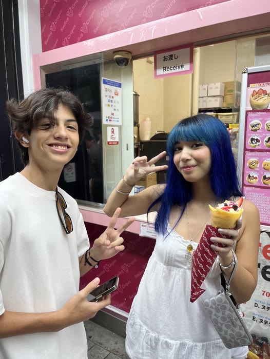 Guests with a crepe, throwing a peace sign in Akihabara