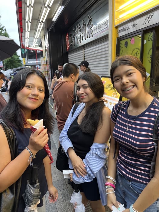 Three guests laughing with street food on the tour