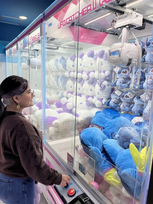 A guest eyeing the plush prizes in a claw machine
