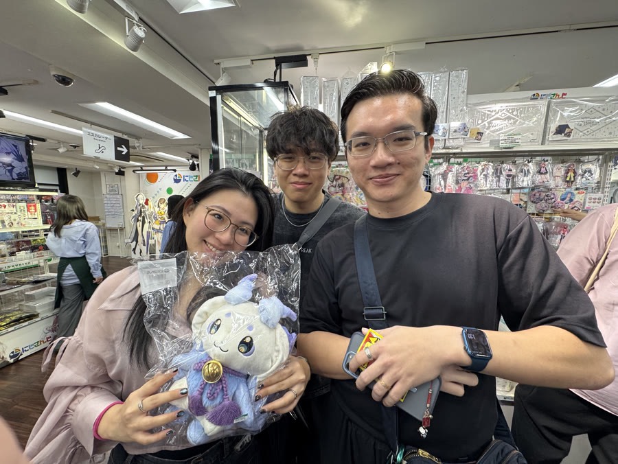 Guests holding a plush toy they found in an anime shop