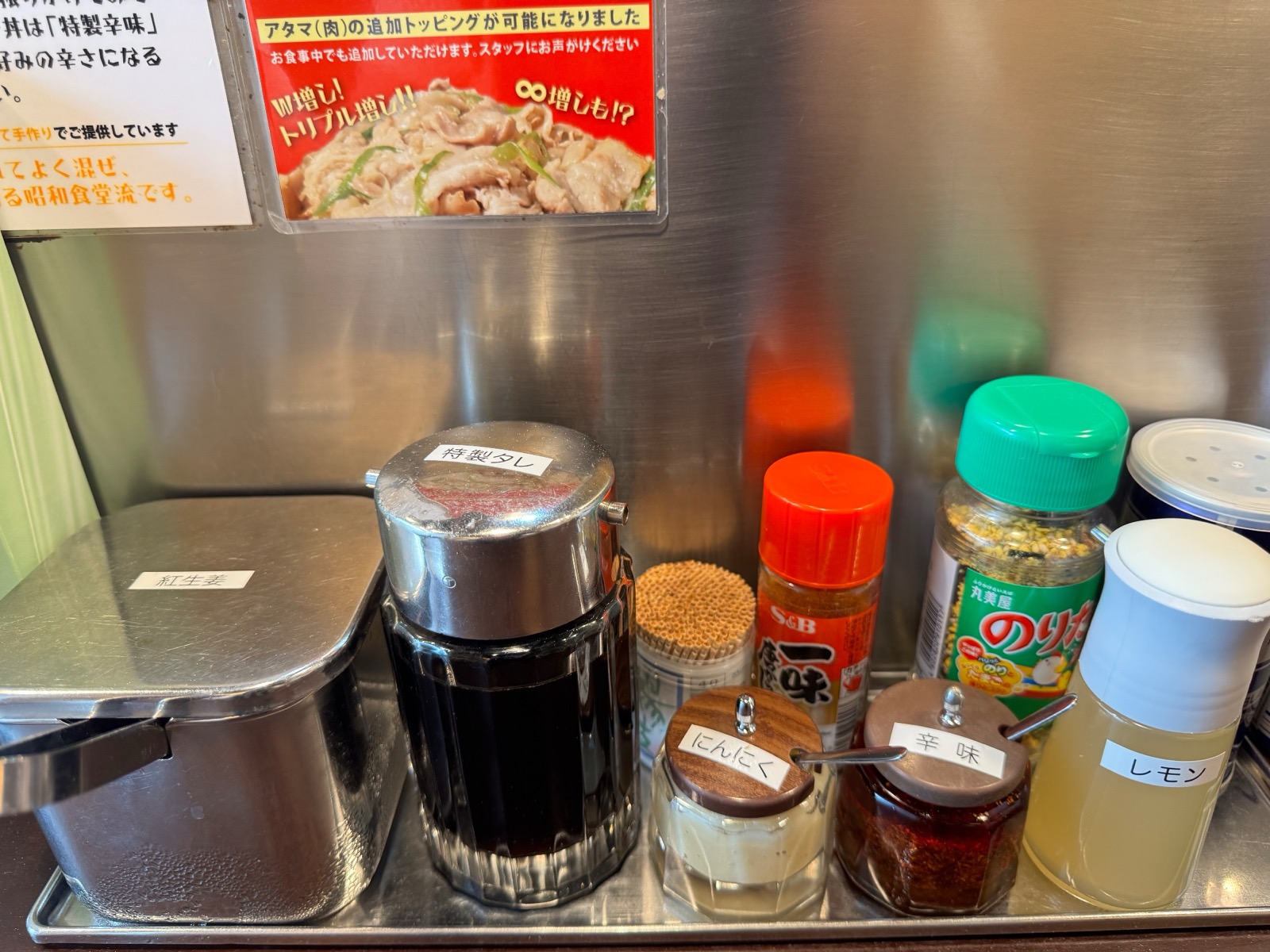 The condiment tray: house sauce, garlic, chilli, lemon, pickled ginger — all free